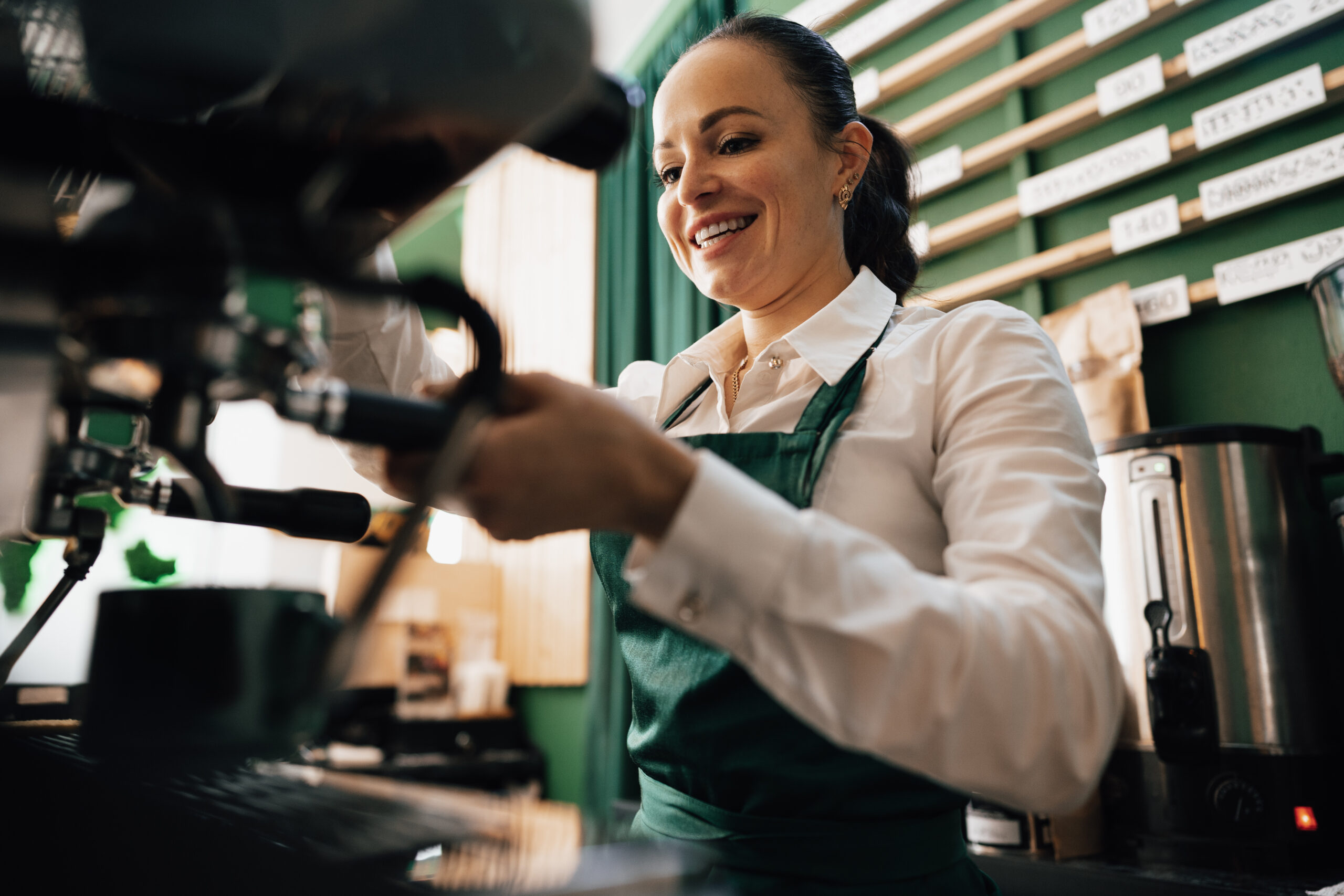 caucasian female barista at work making coffee